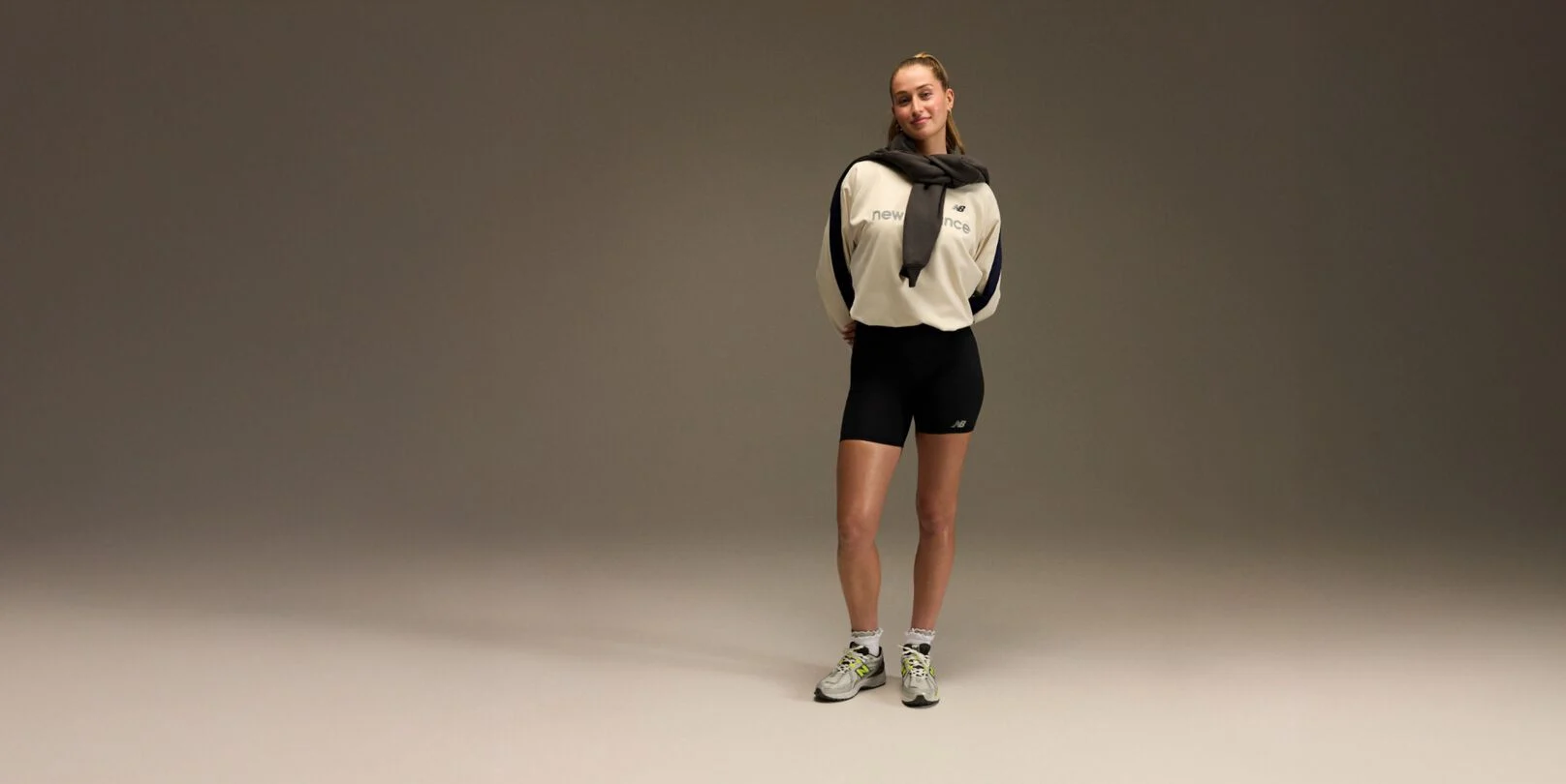Jordyn Huitema standing with an athletic outfit in front of a brown and tan background